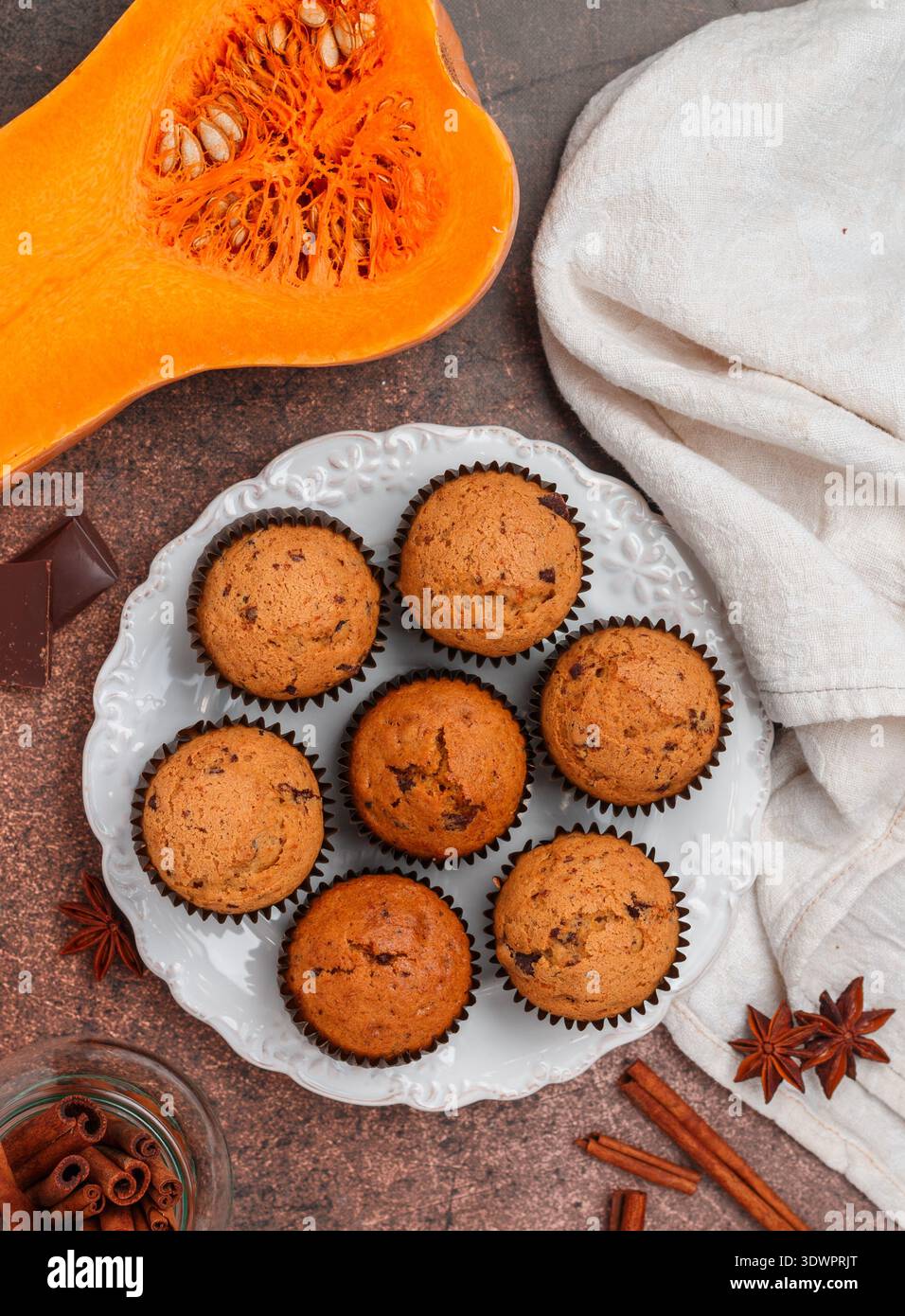 Frisch gebackene hausgemachte Kürbismuffins mit Schokolade und Gewürzen (Zimt, Sternanis, Kardamom). Gesunde hausgemachte Kuchen zum Frühstück. Selektiver lichtwellenleiter Stockfoto