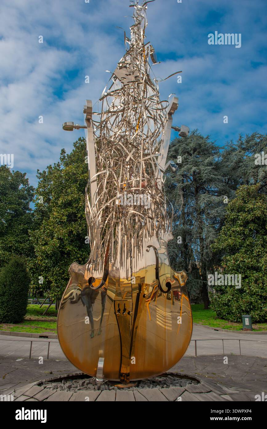 Zeitgenössische Skulptur aus poliertem Metall, die ein großes, stilisiertes Cello im Park von Cremona darstellt Stockfoto