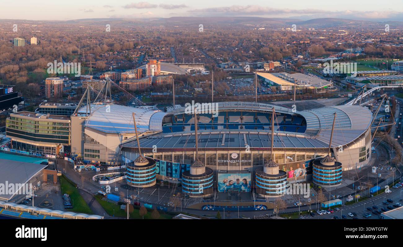Am Etihad Campus in Manchester bei Sonnenuntergang, mit dem erweiterten Nordstand, dem fast vollständigen Medlock Hotel und dem benachbarten Co-op Live Stockfoto