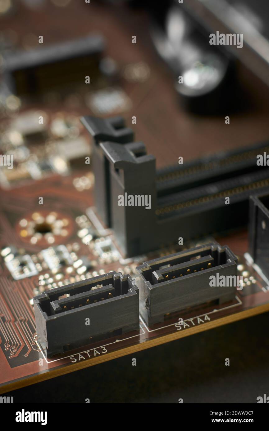 Zwei schwarze sata-Steckdosen aus Kunststoff auf der Motherboard-Oberfläche, metallische Stifte und elektronische Komponenten, Nahaufnahme mit Weichfokus, Datenspeicher Stockfoto