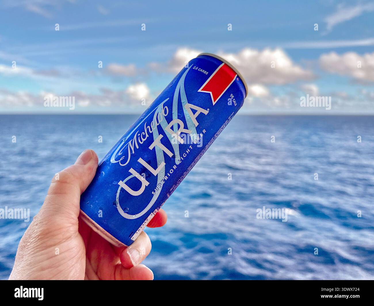 Tortola, Britische Jungferninseln - 18. Januar 2026: Person mit einer Dose kaltem Michelob Ultra Light Beer über dem Deck eines Kreuzfahrtschiffs - Smartphone-aufgenommenes Stockfoto