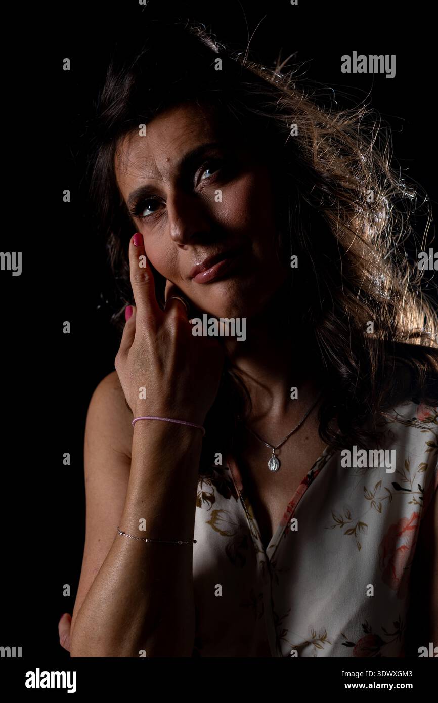Stark beleuchtete Umgebung mit nachdenklichem Künstler und reflektierendem Künstler, eine künstlerische Szene, die introspektive Künstler und Darsteller in sanfter Weise zeigt Stockfoto