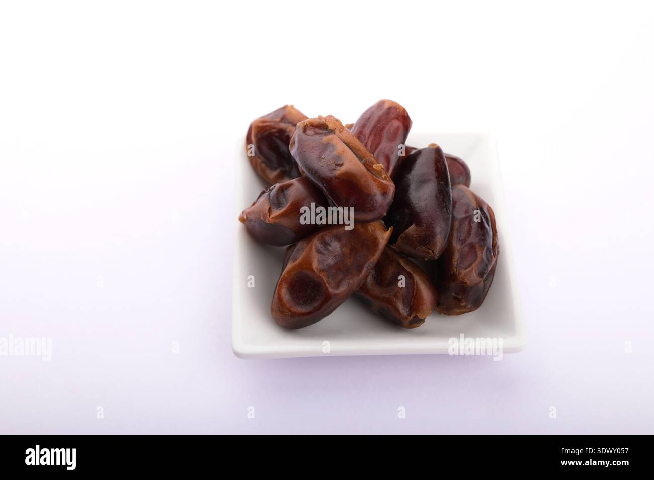 Schüssel mit getrockneten Daten isoliert auf weißem Hintergrund. Frische getrocknete Daten auf weißem Hintergrund. Platte mit getrockneten Daten für Ramadan auf weißem Hintergrund. Stockfoto