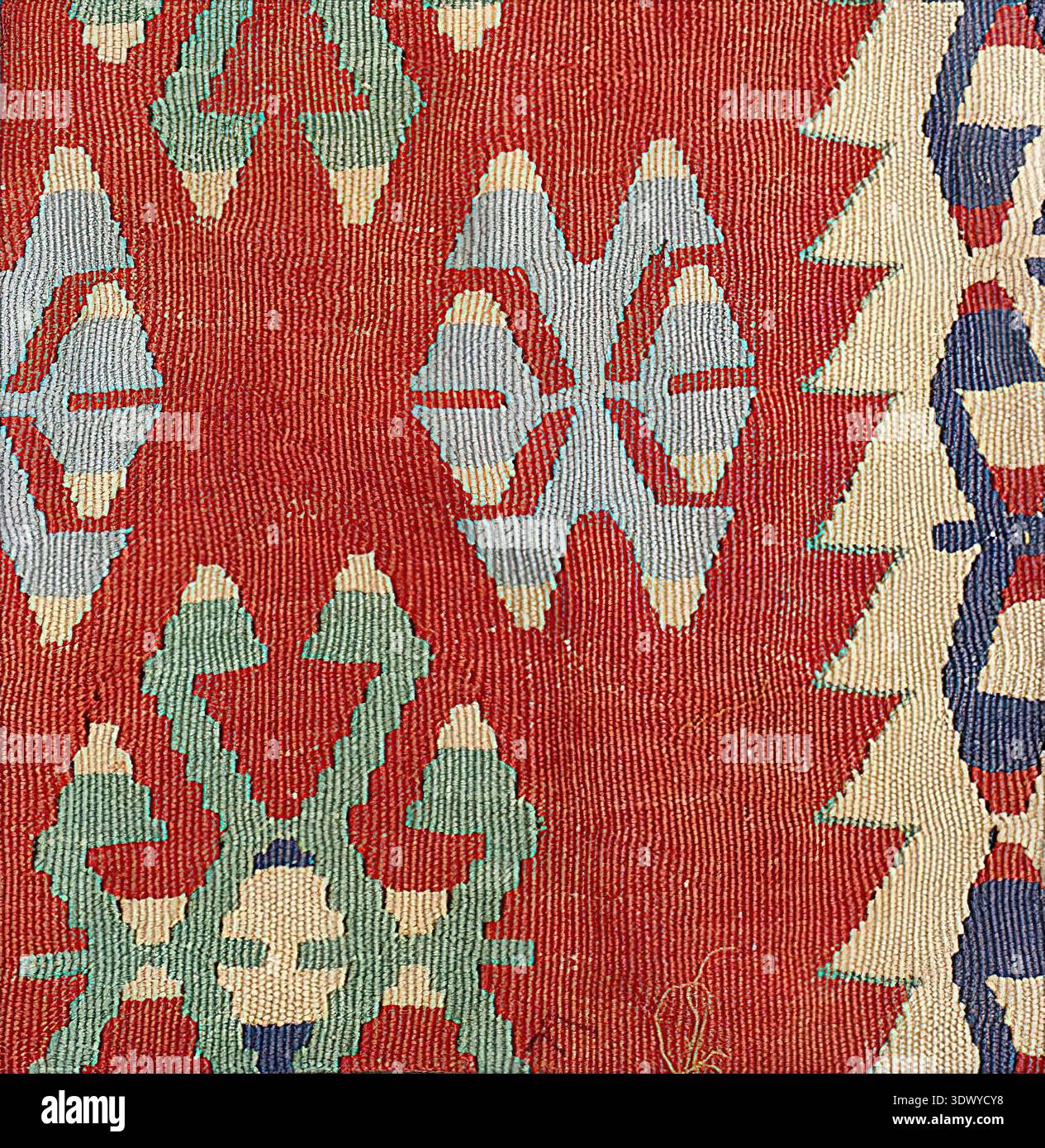Handgewebter Kelims-Teppich mit traditionellen anatolischen geometrischen Mustern in leuchtenden Rot-, Blau-, Grün- und Cremetönen, die ethnische Textilkunst zeigen Stockfoto