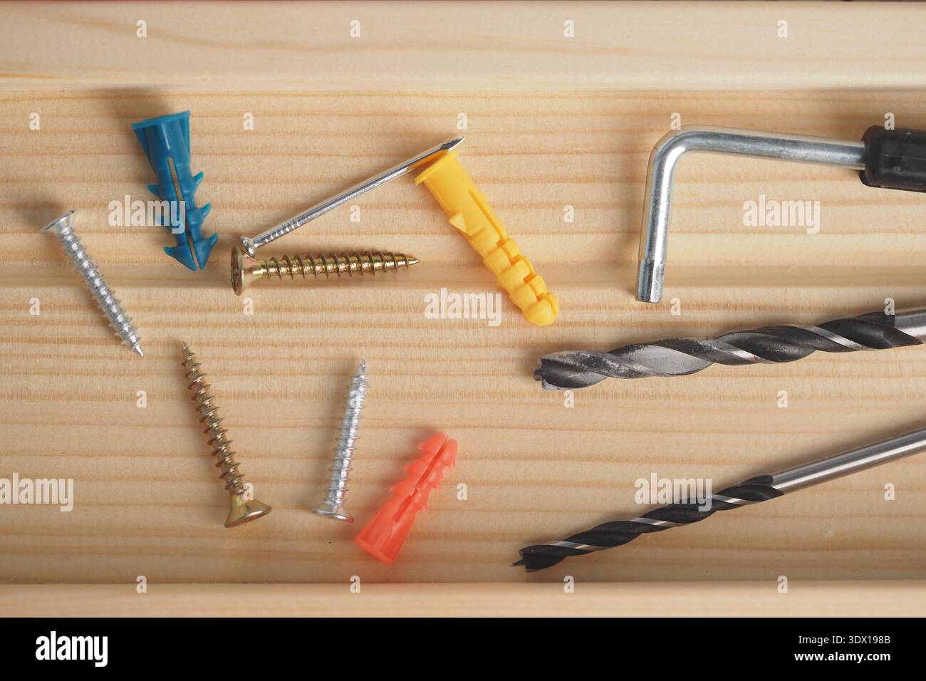 Vielzahl von Werkzeugen und Befestigungselementen auf einer Holzoberfläche Stockfoto