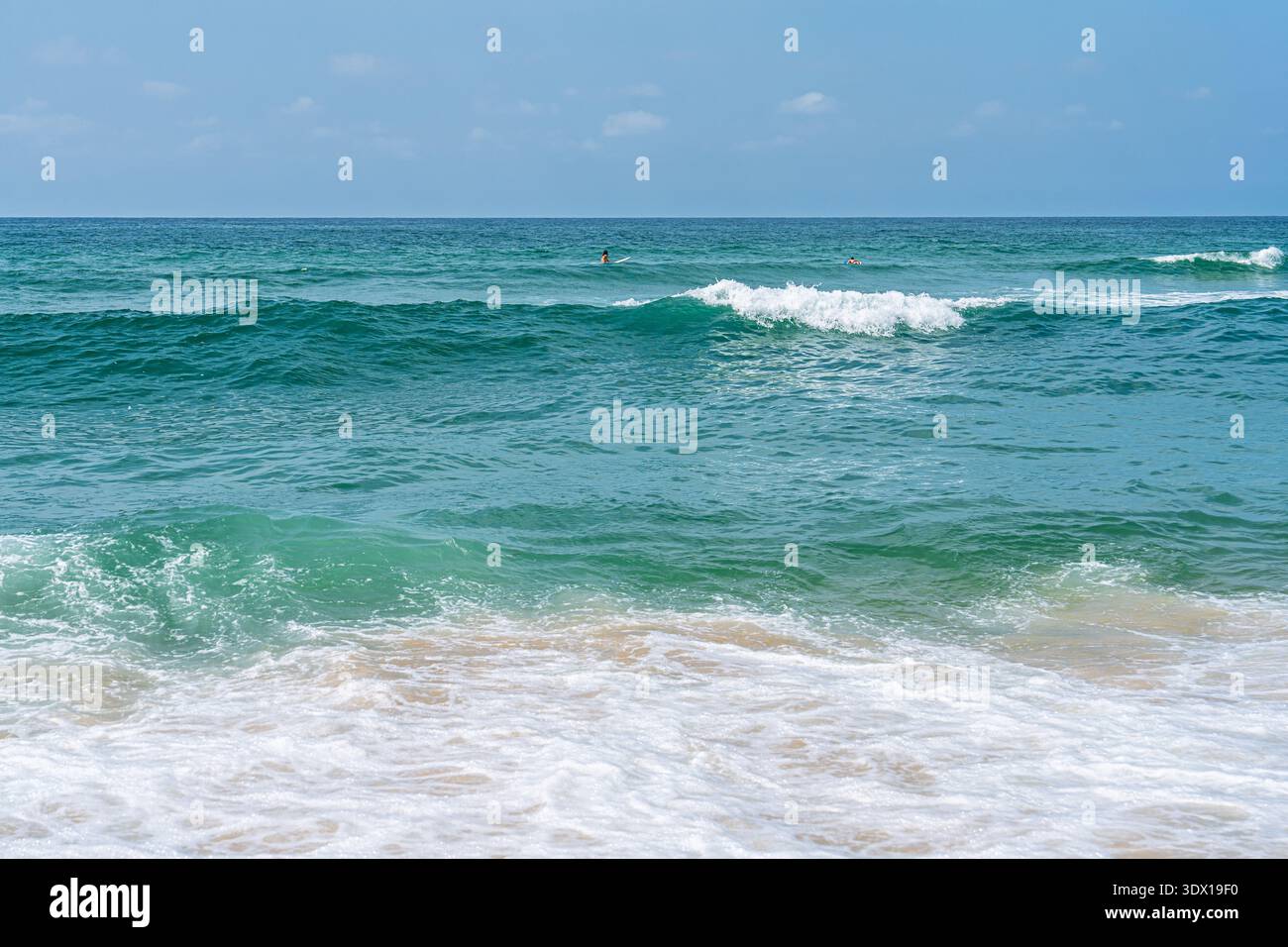 Türkisfarbene Meereswellen stürzen am Sandy Beach ab Und Bieten Einen ruhigen Blick auf die Küstenlandschaft Stockfoto