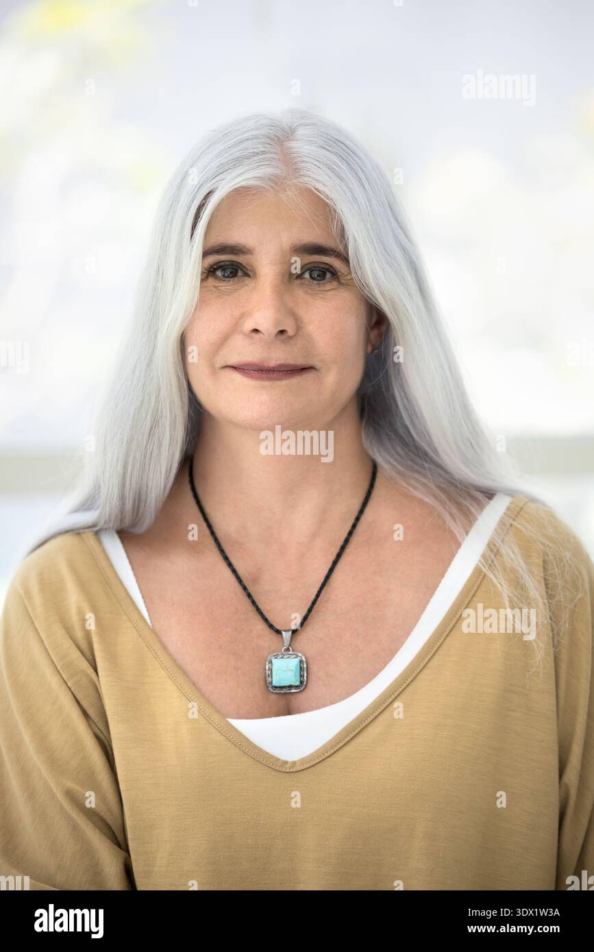 Vertikales Porträt einer fröhlichen hispanischen Frau mittleren Alters Stockfoto