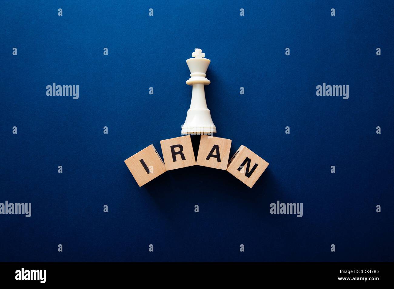 Weißer Schachkönig, der auf Holzblöcken steht, die den iran buchstabieren und Geopolitik und Strategie repräsentieren Stockfoto