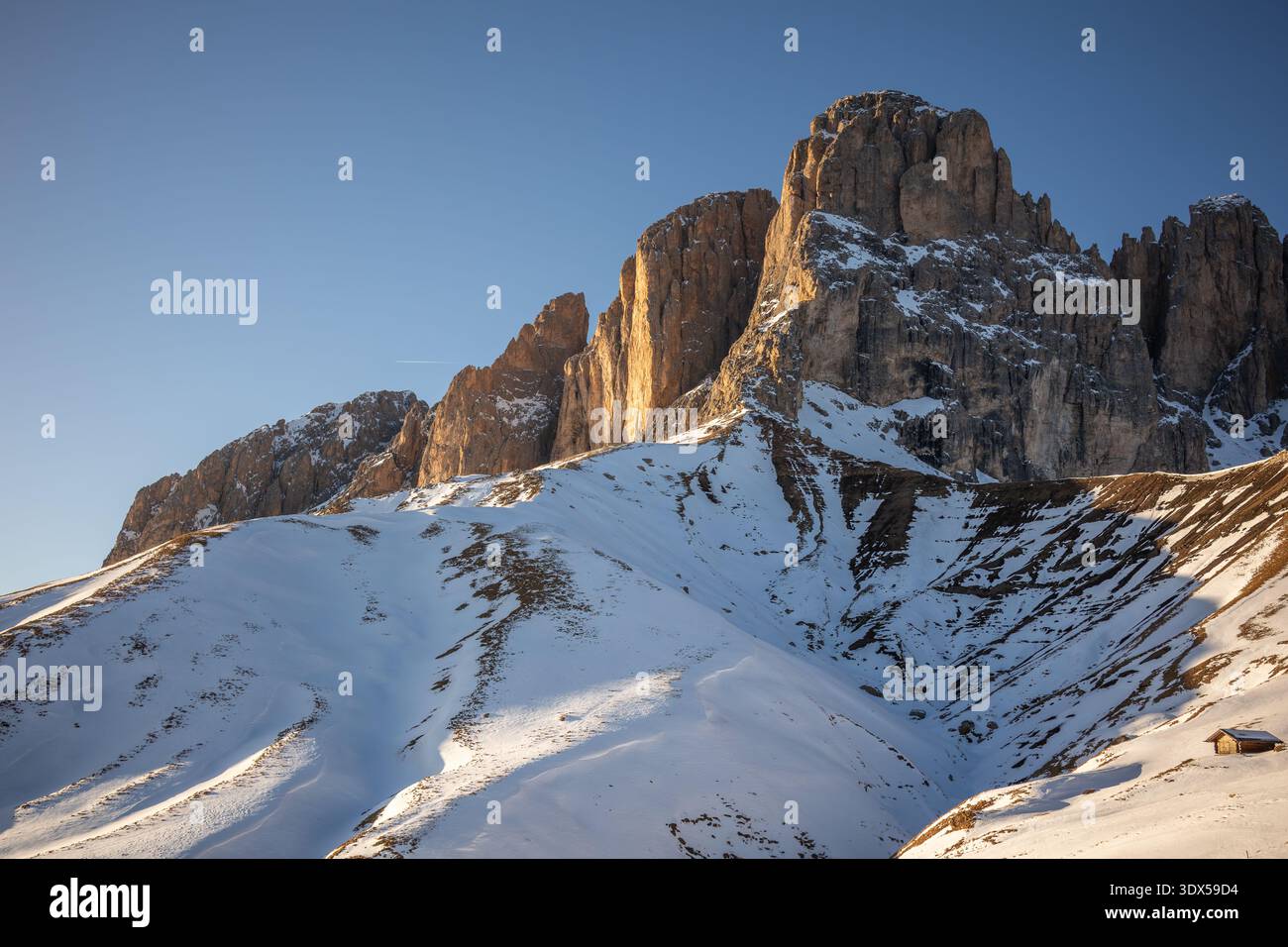 Schneebedeckte Hügel mit felsigen Gipfeln am Nachmittag Golden Hour Light in den Dolomiten. Alpenlandschaft der Berge im Nordosten Italiens. Stockfoto
