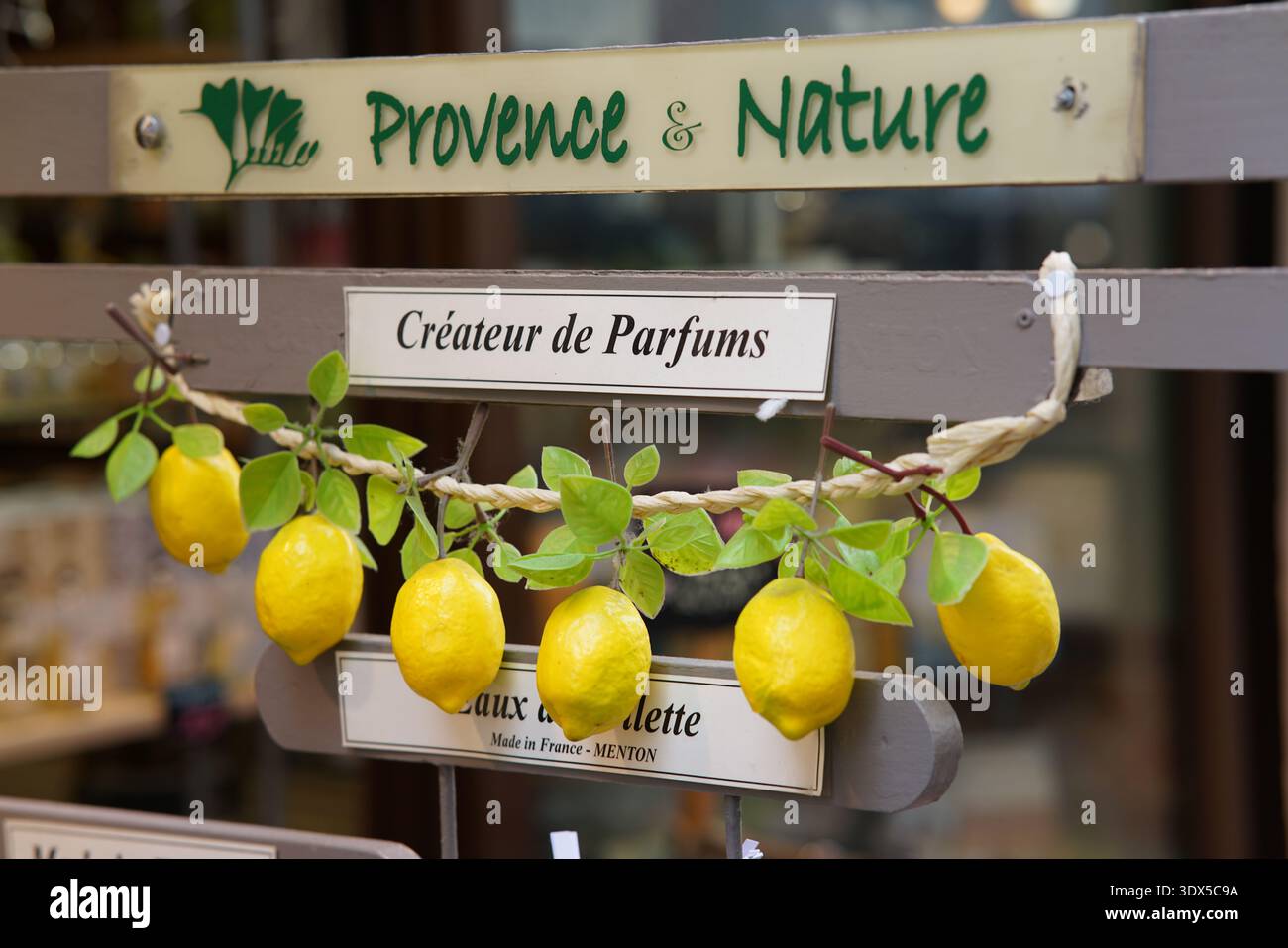 Schild für Parfümladen „Provence & Nature“ in Menton mit „Créateur de Parfums“ und dekorativem Zweig frischer Zitronen. Menton, Frankreich Stockfoto