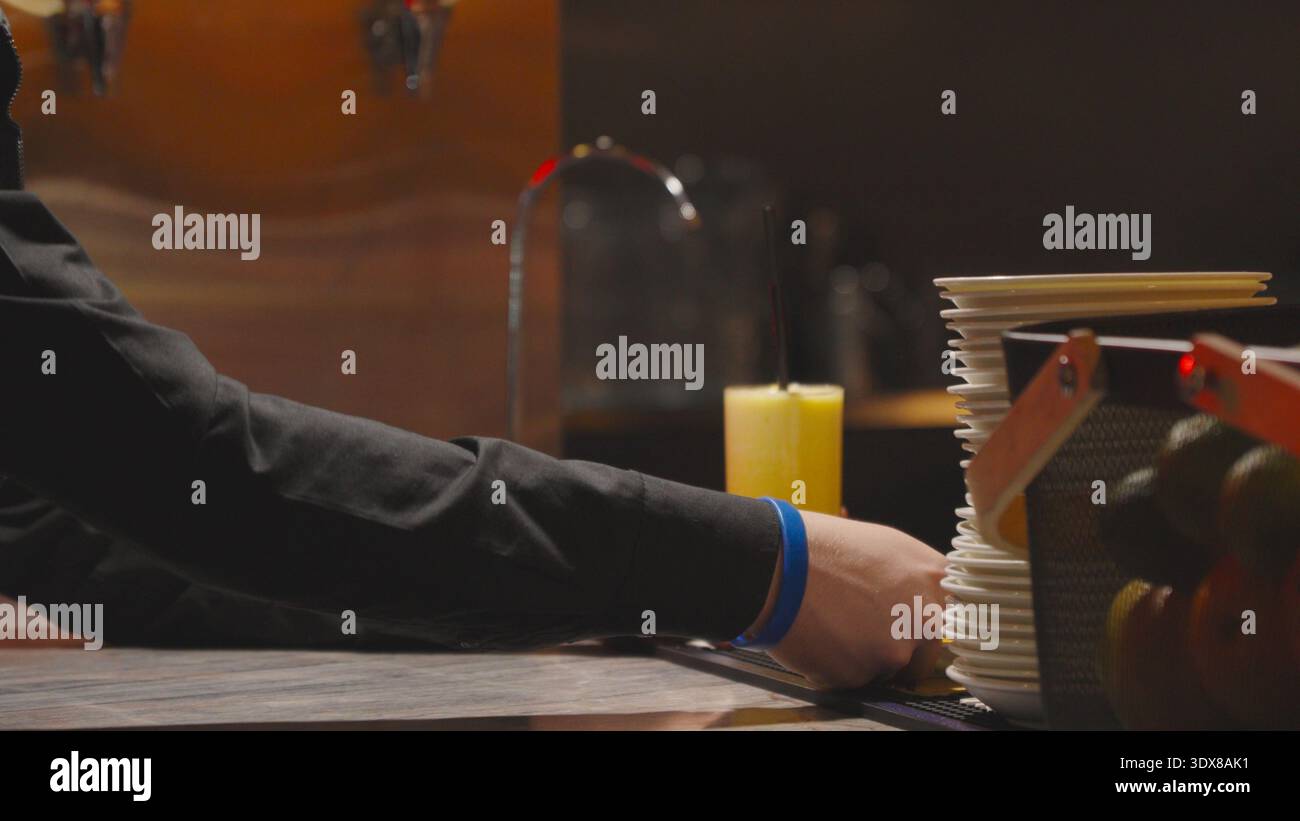 Hand nach einem Glas Orangengetränk an der Bar Stockfoto