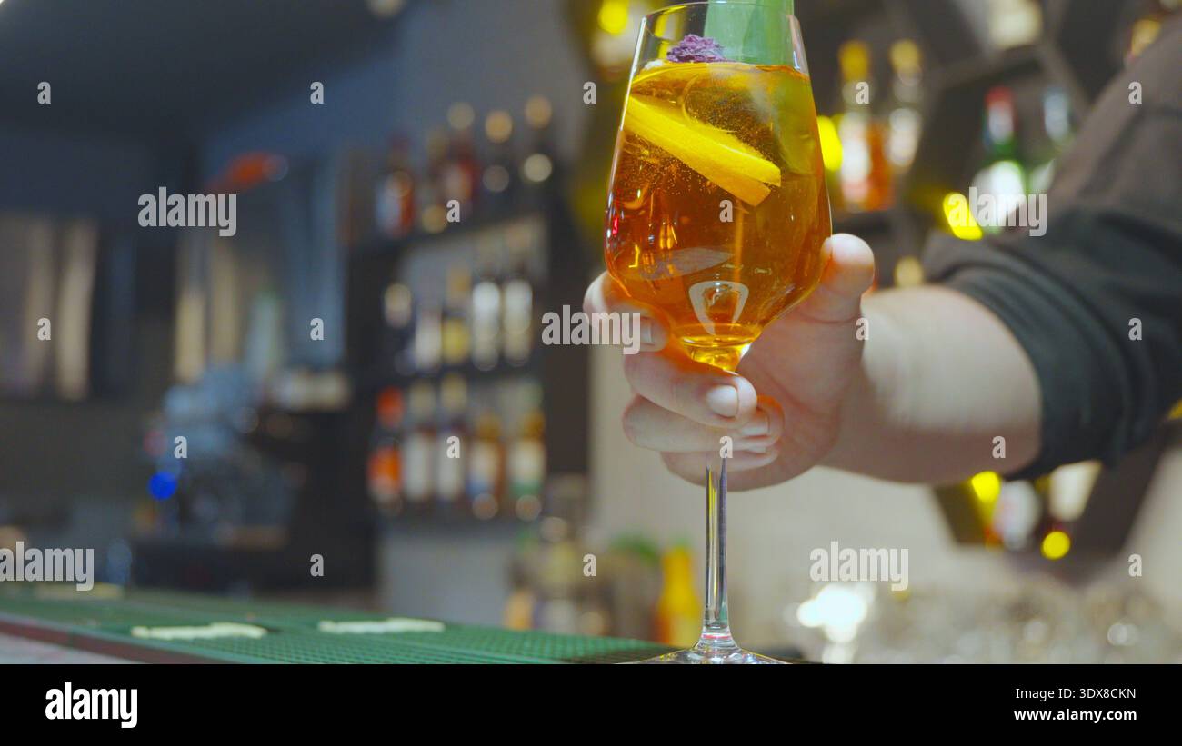 Person mit einem Cocktailglas an der Bar Stockfoto