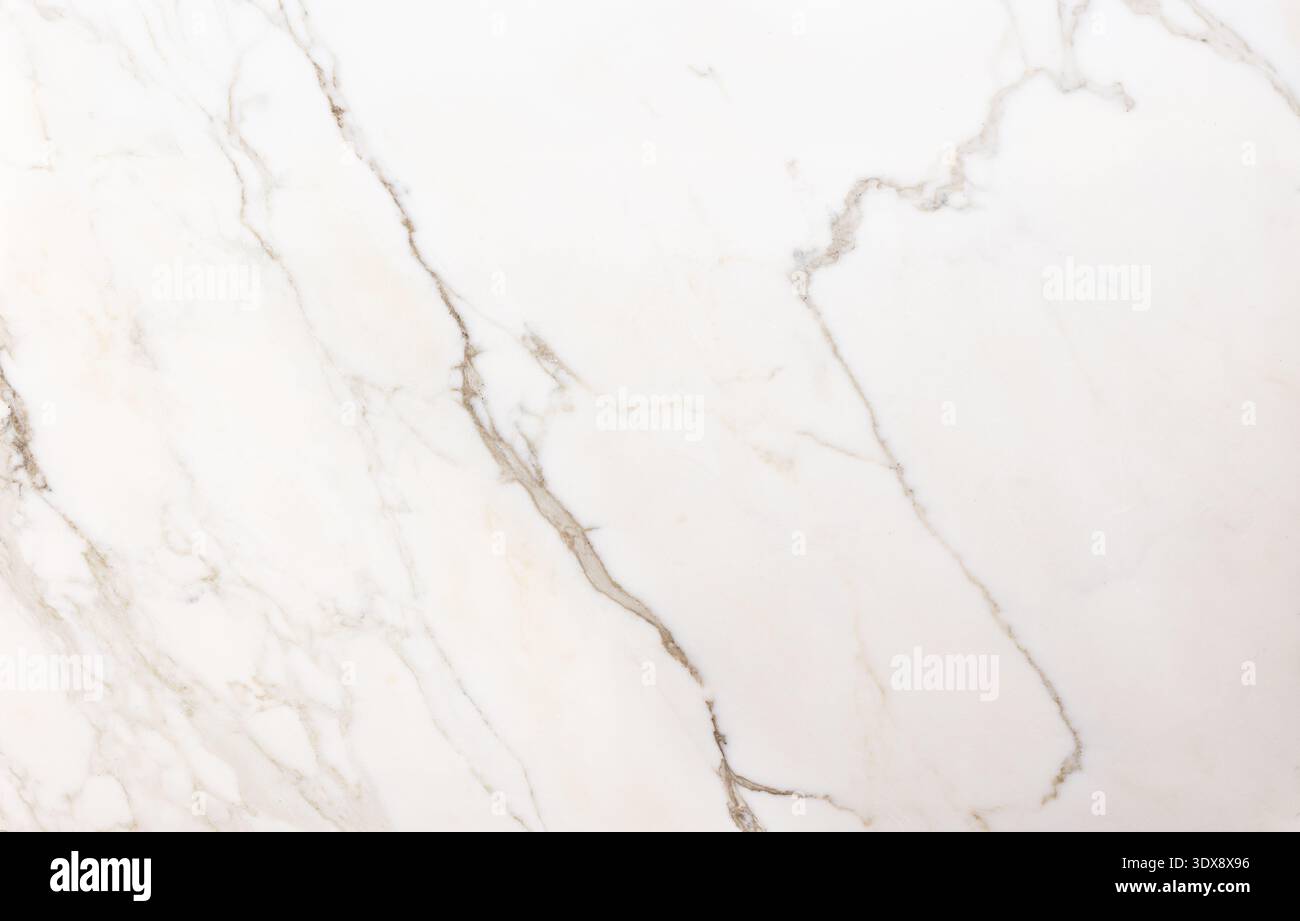 Das Bild zeigt eine Nahaufnahme einer weißen Marmoroberfläche mit natürlichen beigen und grauen Adern. Die organischen Linien schaffen ein elegantes und minimalistisches Muster, hig Stockfoto