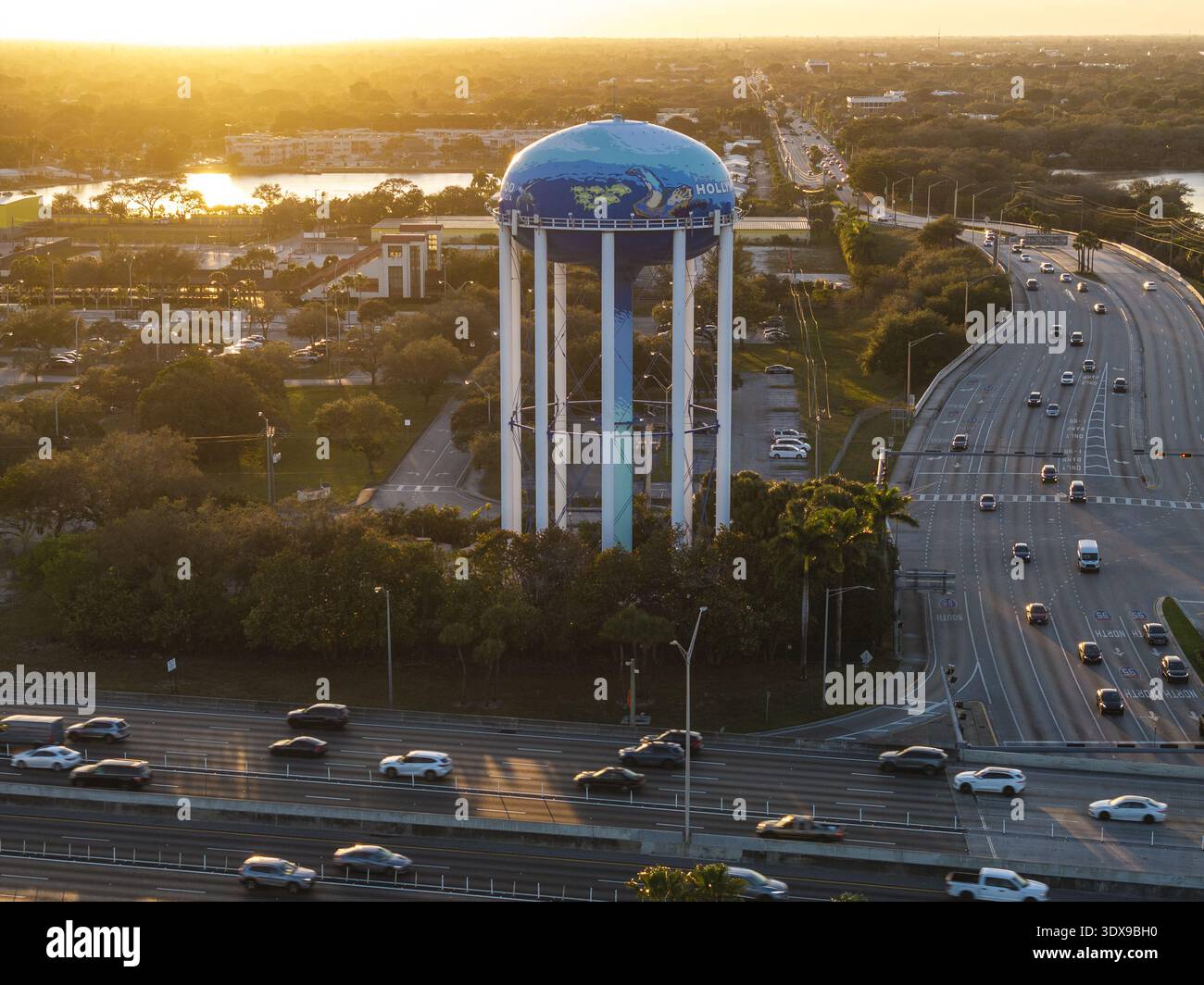Blick aus der Vogelperspektive auf den Wasserturm mit dem Wahrzeichen der Stadt, das hoch steht, während der Verkehr entlang des Highway fließt, Sunrise, Florida, USA. Stockfoto