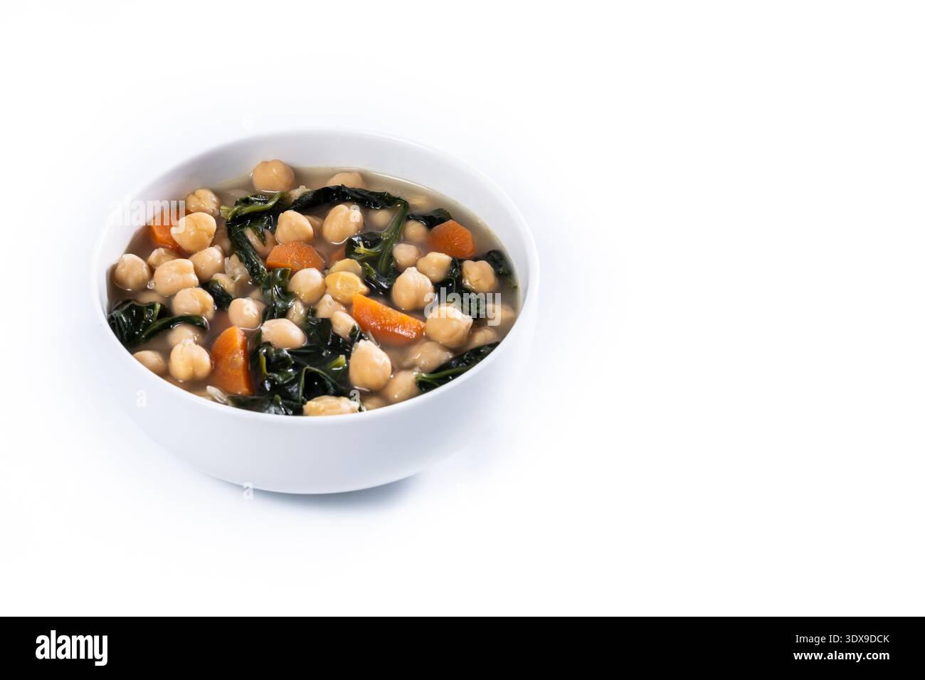 Kichererbsen- und Spinatsuppe mit Karotten in White Bowl auf weißem Marmor Stockfoto