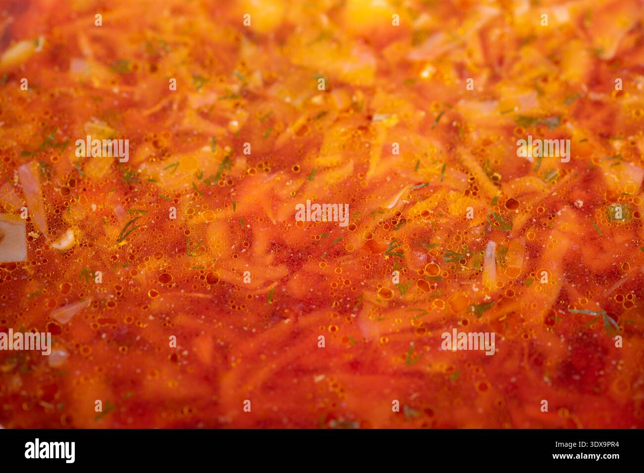 Warme Borschtsuppe, rot, serviert in einer tiefen Schüssel mit Kartoffelstücken und geriebenem Kohl, gehackten Kräutern, nostalgischem Aroma und wohltuender Kälte Stockfoto
