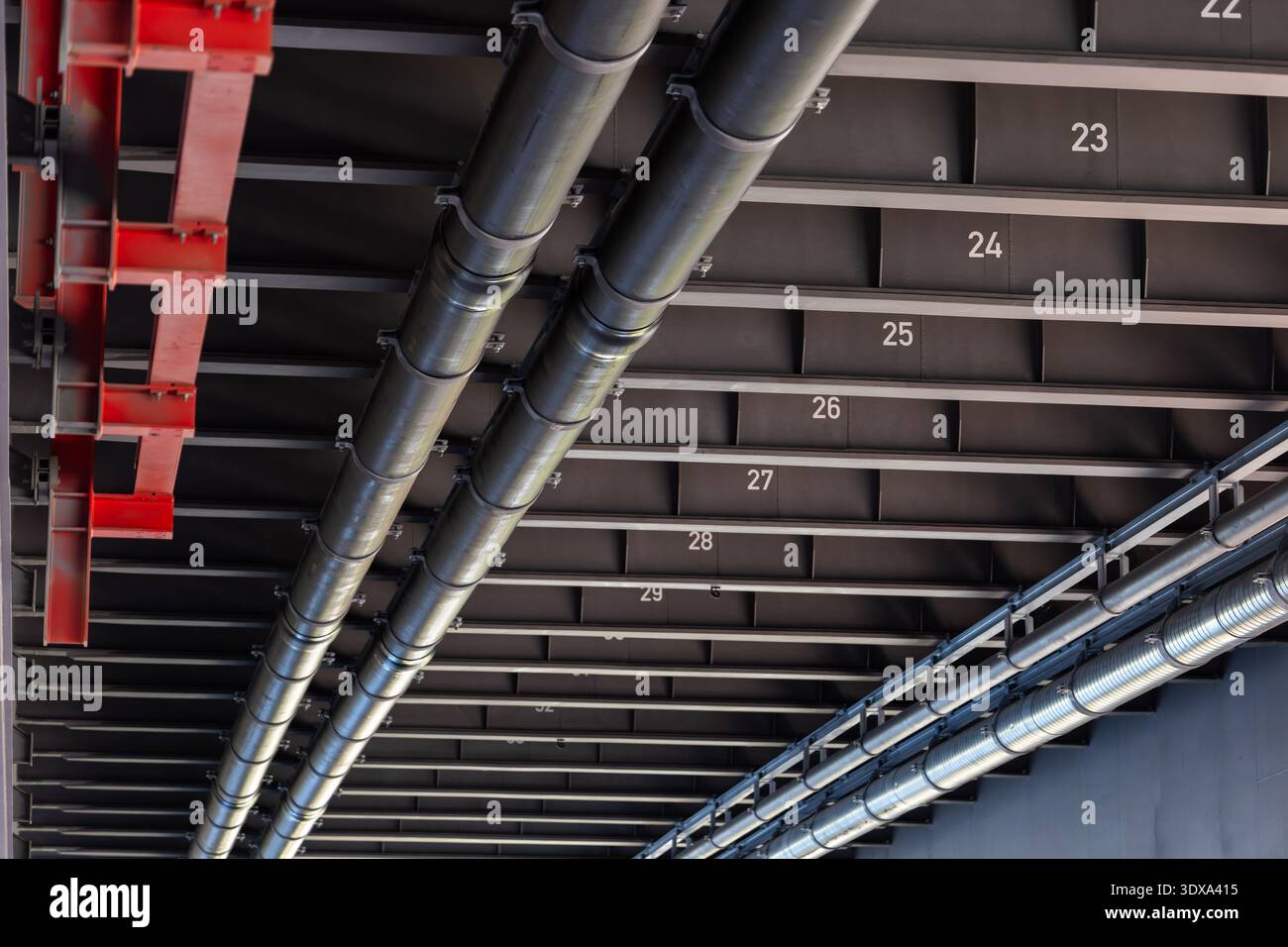 Stahlbrückeninfrastruktur Rohrleitungen Kanäle installierten Metallträger nummerierte Balken unter der Fahrbahn. Wirtschaftsingenieurbau moderner Verkehr Stockfoto