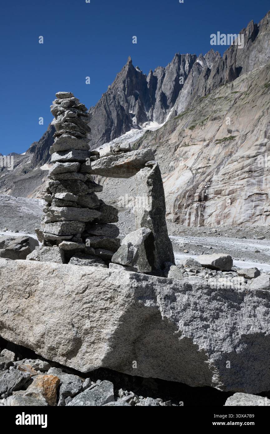 Der Gletscherbach auf dem Gletscher Mer de Glace mit den Aigulles-Türmen im Hintergrund. Stockfoto