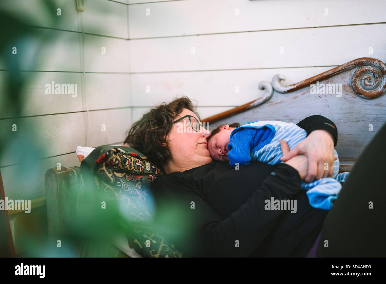 Großmutter schläft mit Enkel zu Hause auf dem Sofa Stockfoto