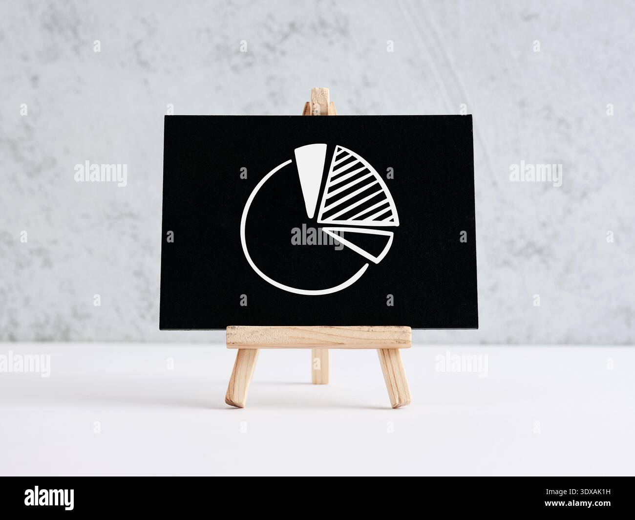 Tortendiagramm-Symbol auf einem kleinen schwarzen Schwarzen Schwarzen Brett, das Datenanalysen, Marktanteile und Konzepte für das finanzielle Wachstum anzeigt Stockfoto