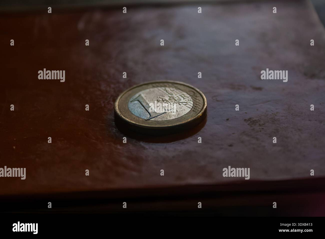 Eine Nahaufnahme einer 1-Euro-Münze auf einer braunen Lederoberfläche. Stockfoto