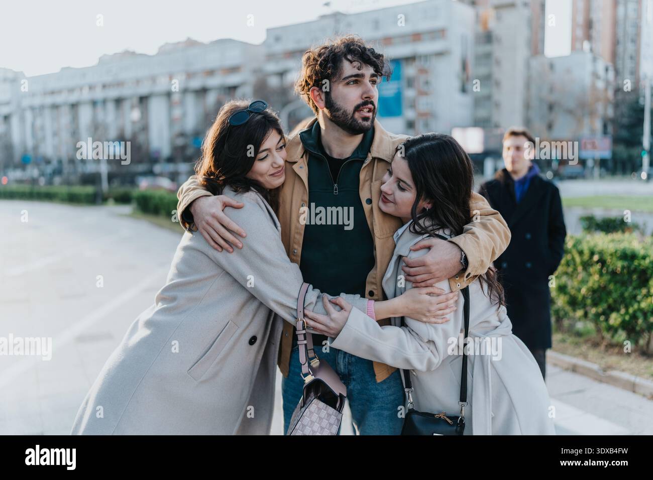 Eine Gruppe von Freunden und Familie, die sich in einer urbanen Umgebung umarmen Stockfoto