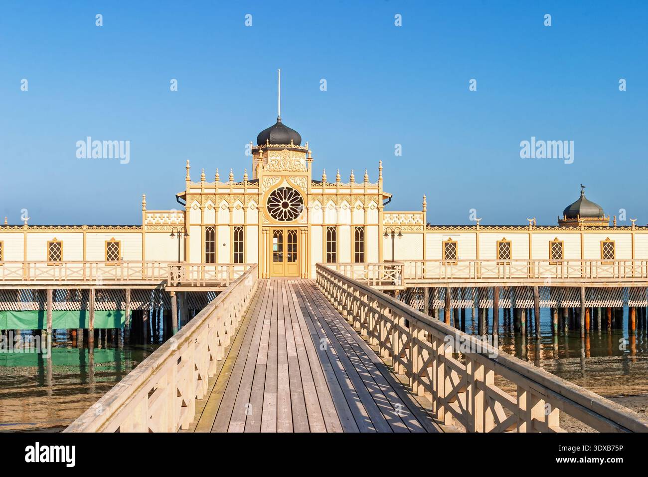 Holzpier-Pavillon mit zentralem Turm und Kuppel am Meer unter klarem blauen Himmel Stockfoto