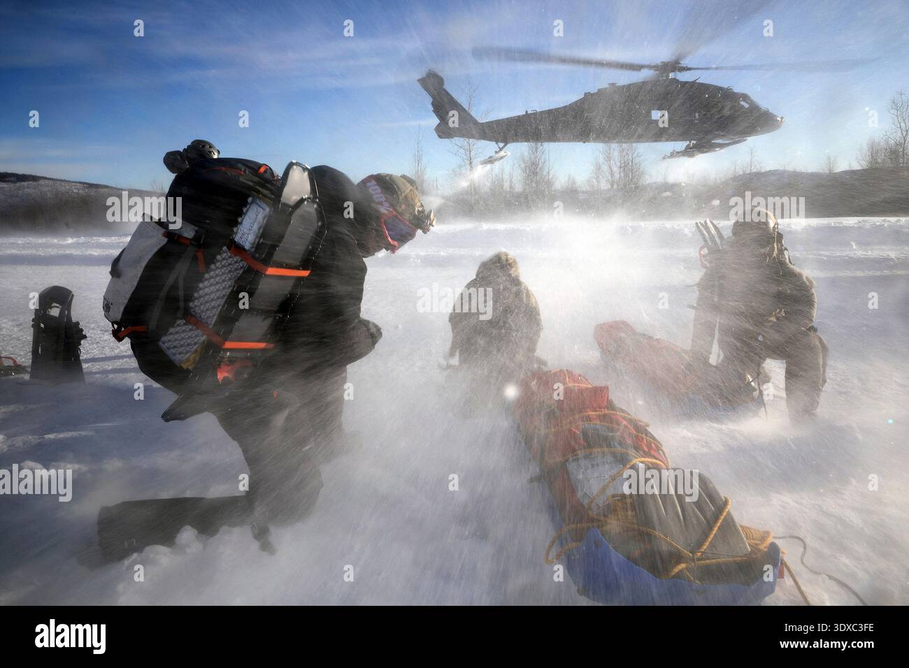 Die Teilnehmer der Special Operations Forces Arctic Medic 2025 (SOFAM 25) schützen sich vor der Rotorspülung eines abfliegenden Hubschraubers der US Army UH-60L Black Hawk, der der Alpha Company, 1-52D General Support Aviation Battalion, zugewiesen wurde, während des Arctic Medical Trainings im Yukon Training Area, Fort Wainwright, Alaska, 19. Februar 2025. SOFAM 2025 ist ein Training und Validierungs-Event des Special Operations Command North für Einheitsmediziner, die regelmäßig Übungen und Operationen in der Nordamerikanischen Arktis durchführen. Nur Redaktionelle Verwendung. Nicht zur Bestätigung. Quelle: Alaska National Guard / Alejandro PE–A. Stockfoto