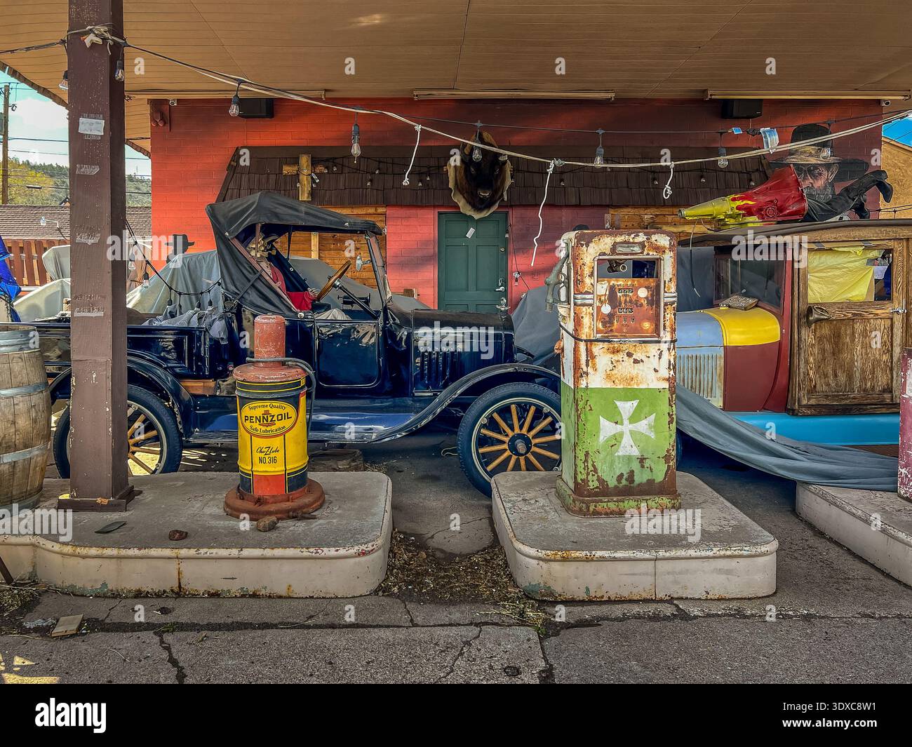 Winslow, USA - 22. April 2022: Oldtimer und Gaspumpen stehen als Relikte unter einem verwitterten Baldachin und malen eine nostalgische Szene von AME Stockfoto
