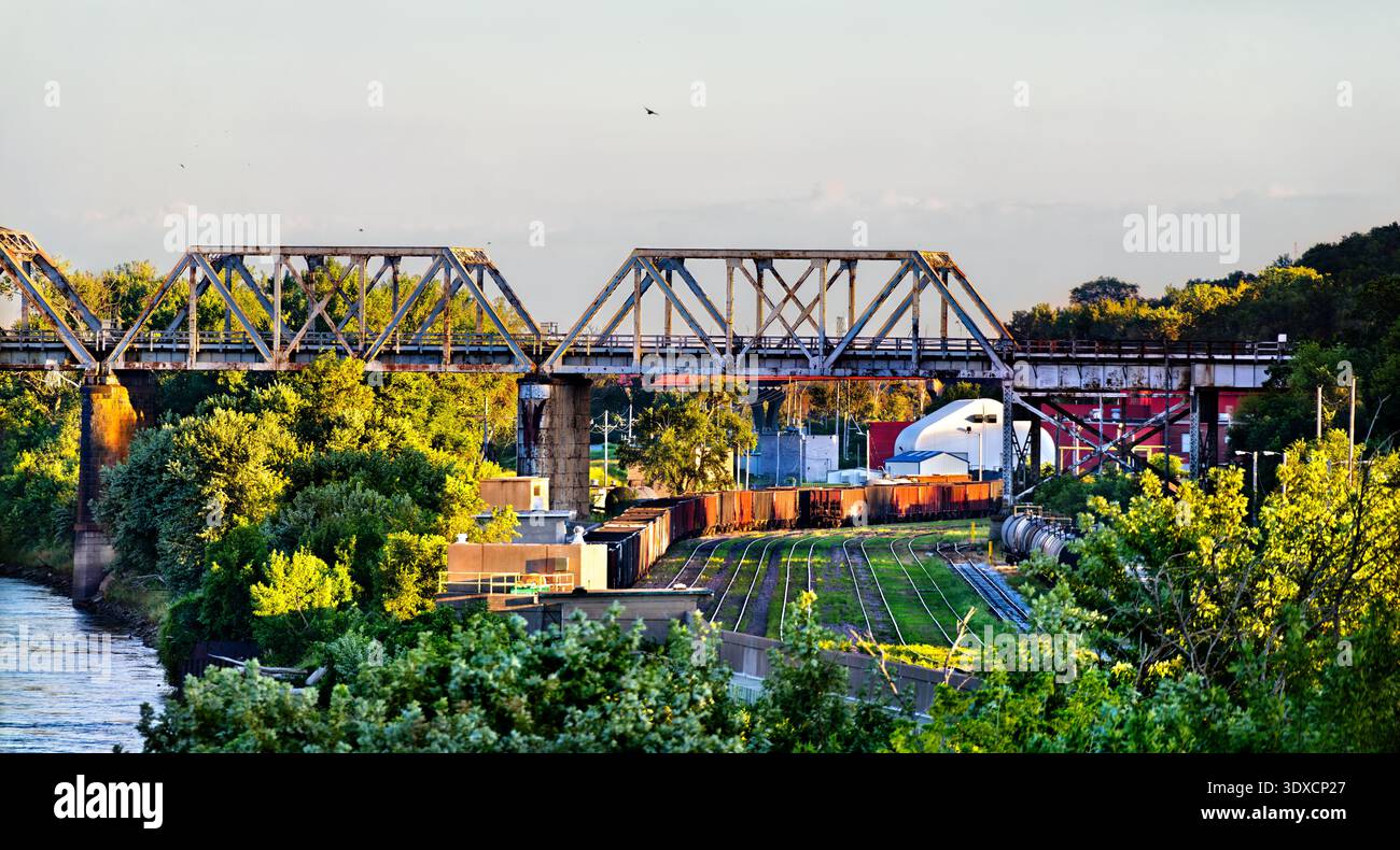 Malerischer, sonniger Blick auf einen Güterzug und die historische Union Pacific Missouri River Bridge aus Stahl, die das Wasser am Omaha River überspannt. Stockfoto