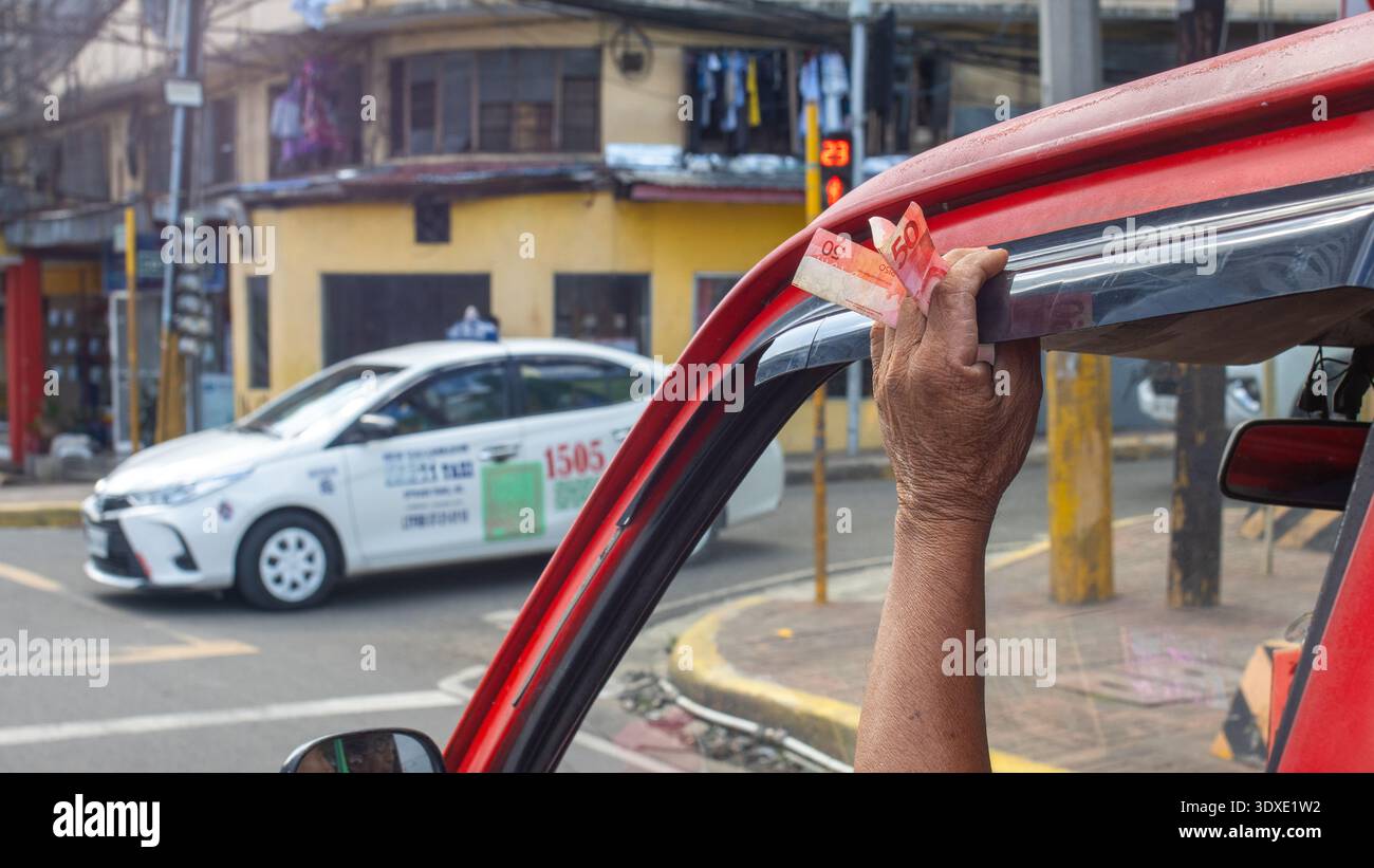 Hand hält philippinische Peso Barscheine in einem Jeepney in Cebu City Stockfoto