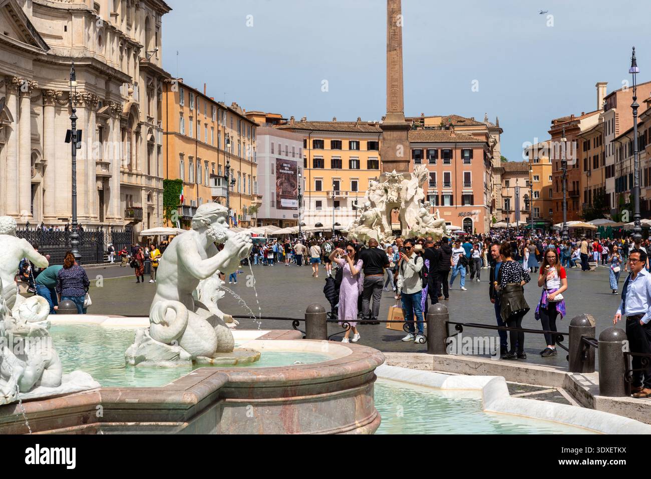 Rom, Italien – 20. April 2025: Skulpturen von Brunnen und Besucher auf der Piazza Navona, umgeben von historischen Gebäuden und lebhaftem Stadtleben in einem der Städte Roms“ Stockfoto