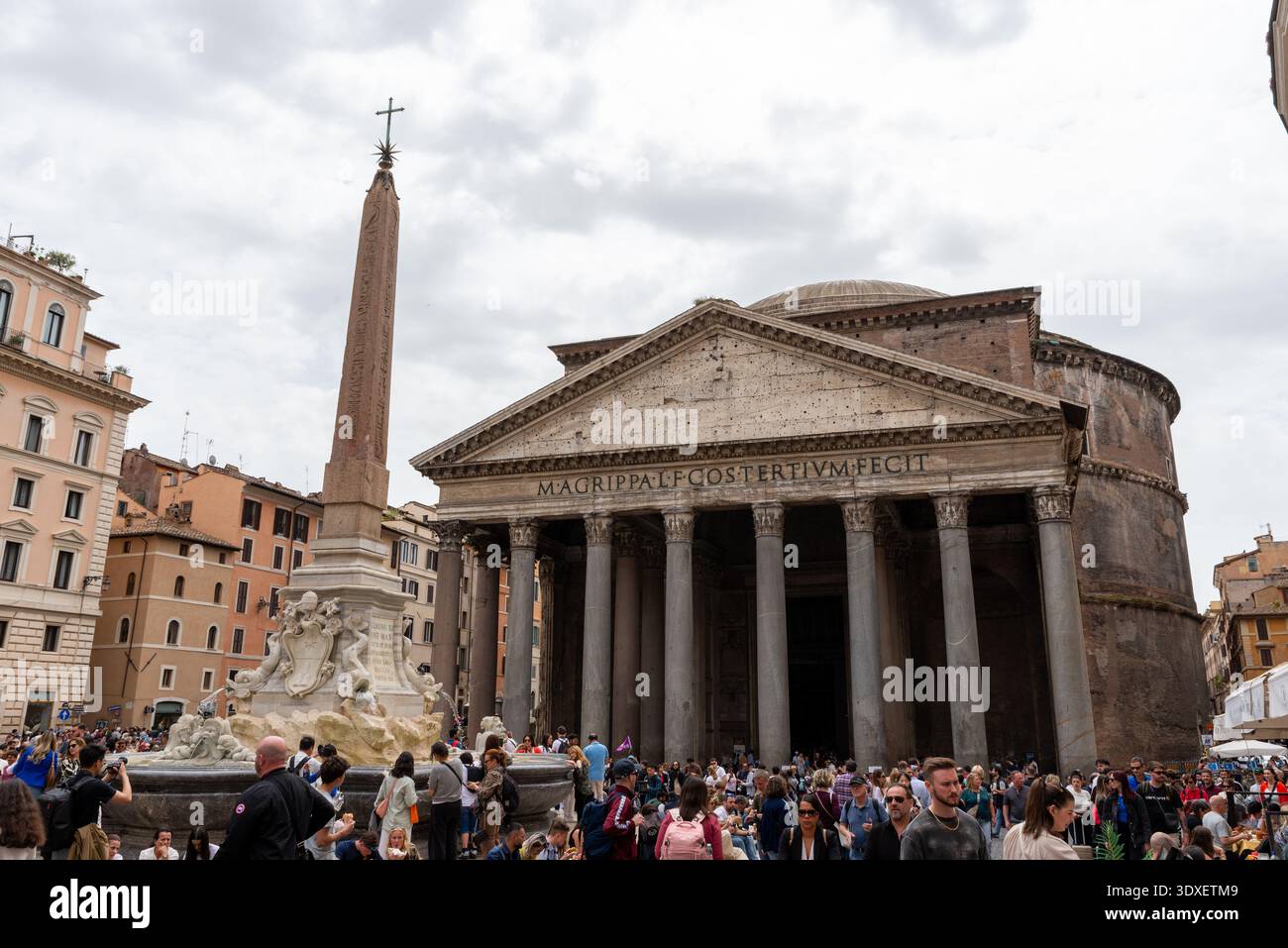 Rom, Italien – 20. April 2025: Das Pantheon und der zentrale Brunnen dominieren den belebten Platz, während sich Besucher unter den antiken römischen Säulen und dem Turm versammeln Stockfoto
