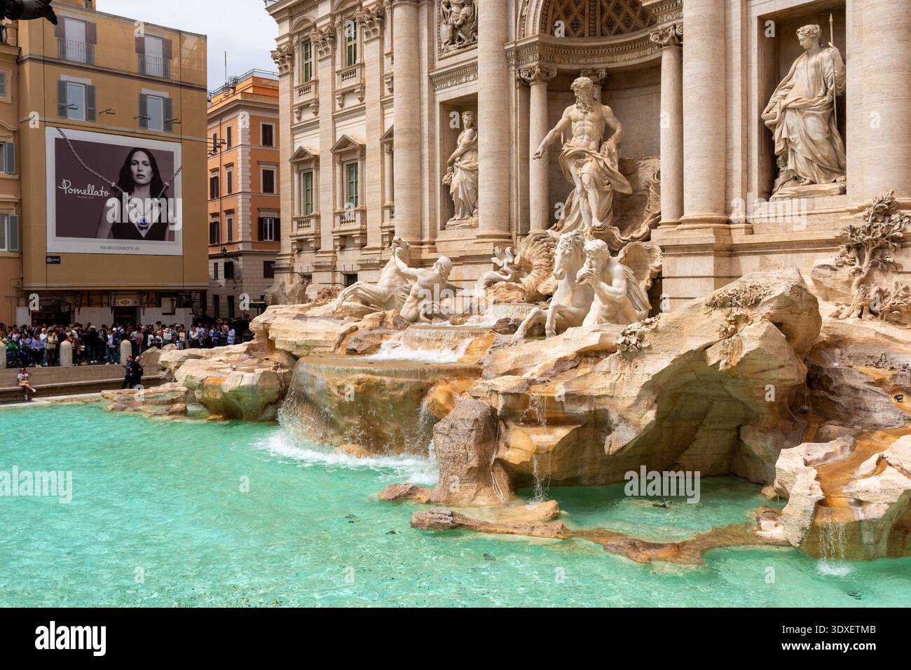 Rom, Italien – 20. April 2025: Touristen versammeln sich um den Trevi-Brunnen und bewundern barocke Skulpturen und türkisfarbenes Wasser in einem der größten sehenswürdigkeiten der Stadt Stockfoto
