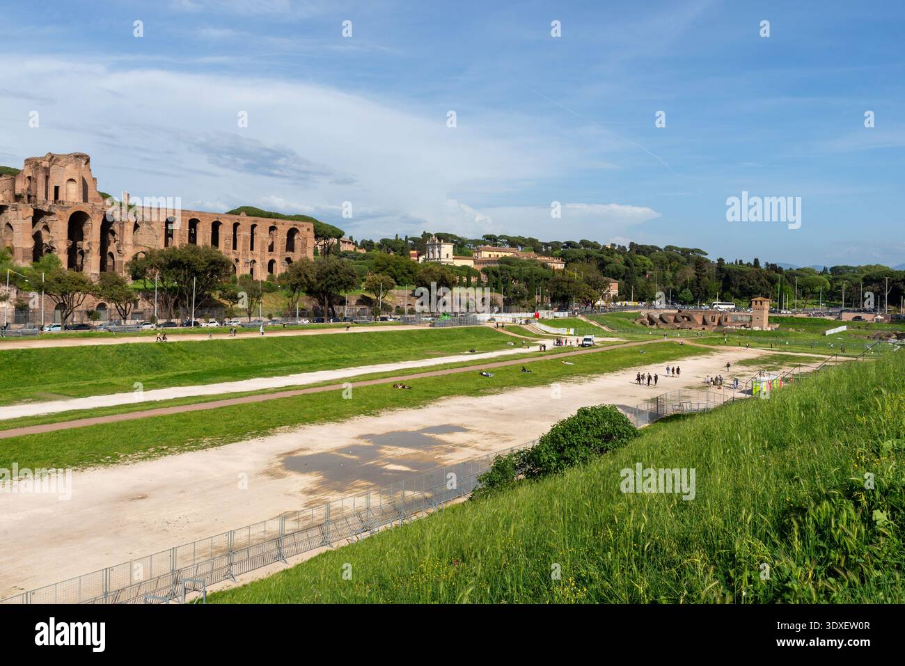 Rom, Italien – 21. April 2025: Ruinen des Circus Maximus mit alten Ziegelbauten und offenem Grünfeld unter großem Himmel Stockfoto