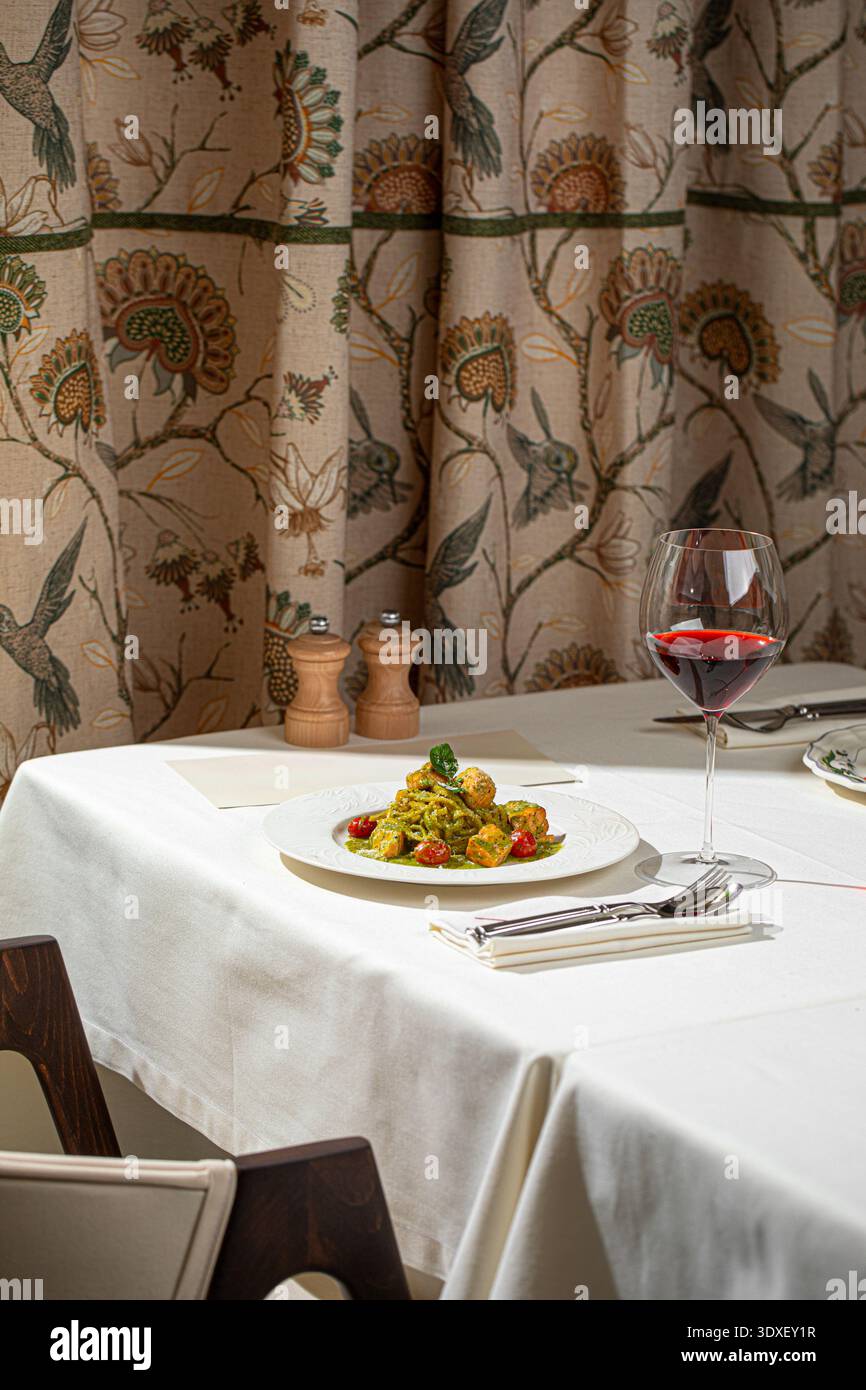 Grüne Pesto-Pasta mit Lachs und Rotwein Stockfoto