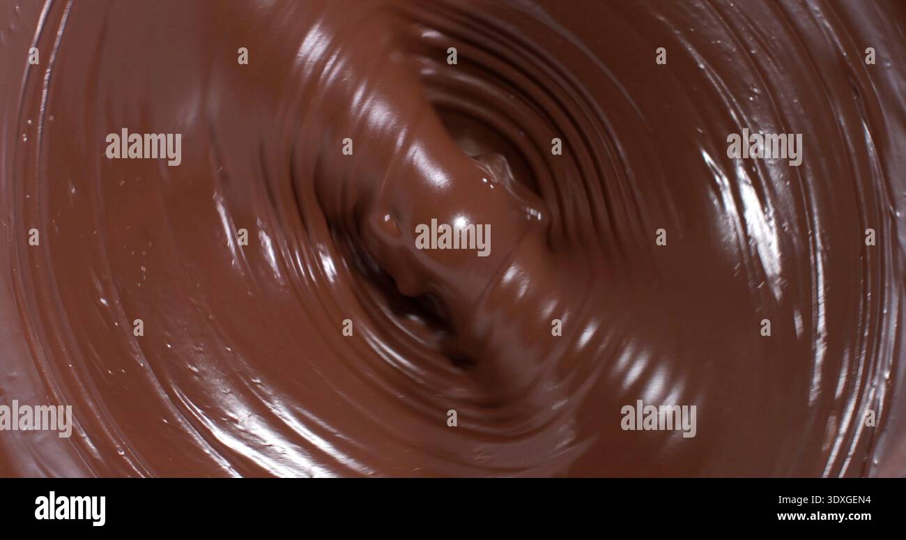 Schwirrende Schokolade in einer Schüssel während der Zubereitung von Desserts in einer Küche Stockfoto