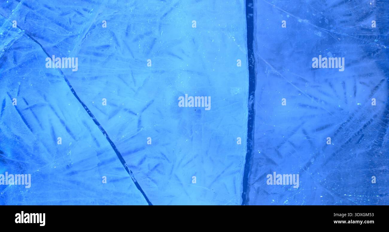Die Eisoberfläche zeigt detaillierte Linien und Muster, die das Licht an einem kalten Wintertag in einem blauen Farbton reflektieren Stockfoto