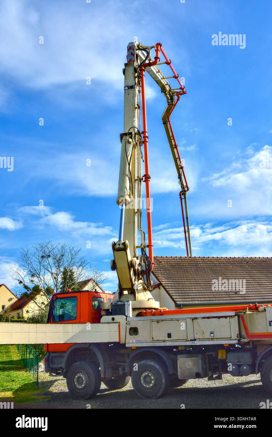 Schwing S 45 S Auslegerpumpe zur Versorgung von Frischbeton über das Hausdach zum hinteren Gartenbereich - Bossay-sur-Claise, Indre-et-Loire (37), Frankreich. Stockfoto