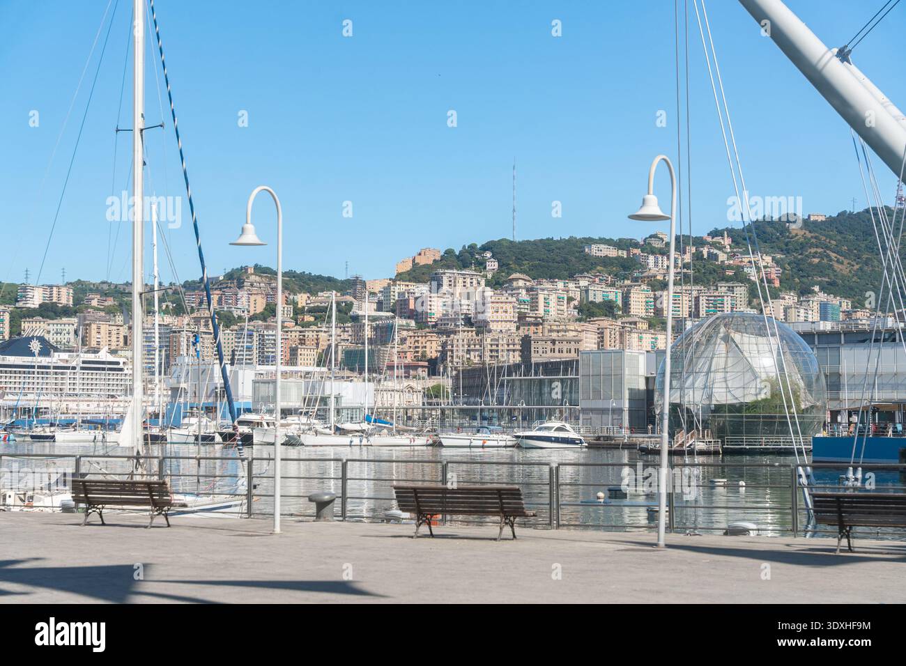 Genua, Italien, 07.08.26, städtische Küstenlandschaft mit Booten und Hügeln im Hintergrund. Konzept von Reise, Freizeit und europäischem Sommer-Lifestyle. Stockfoto