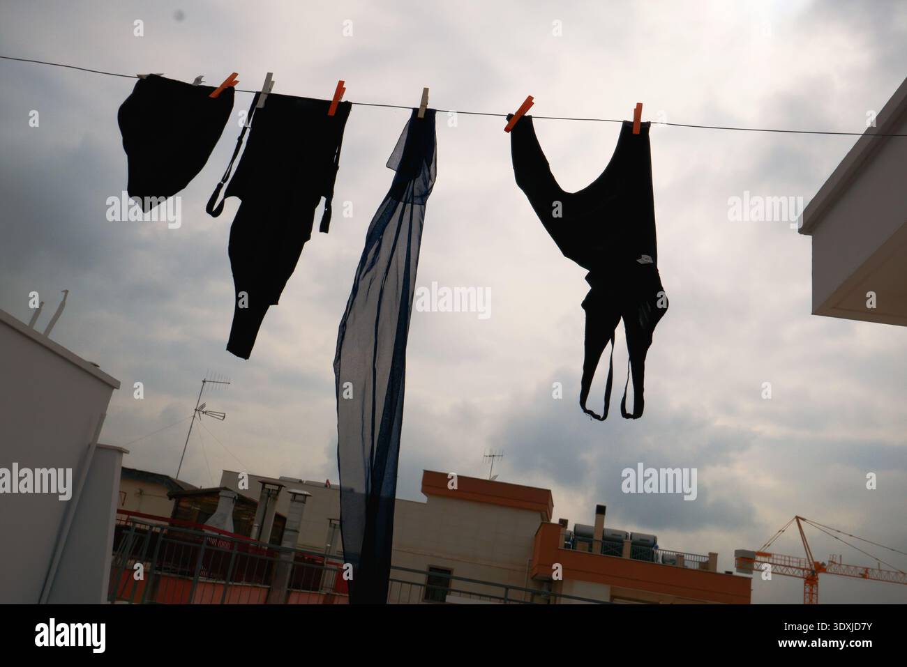 Kleidung hängt an einem bewölkten Morgen auf der Terrasse zum Trocknen. Stockfoto