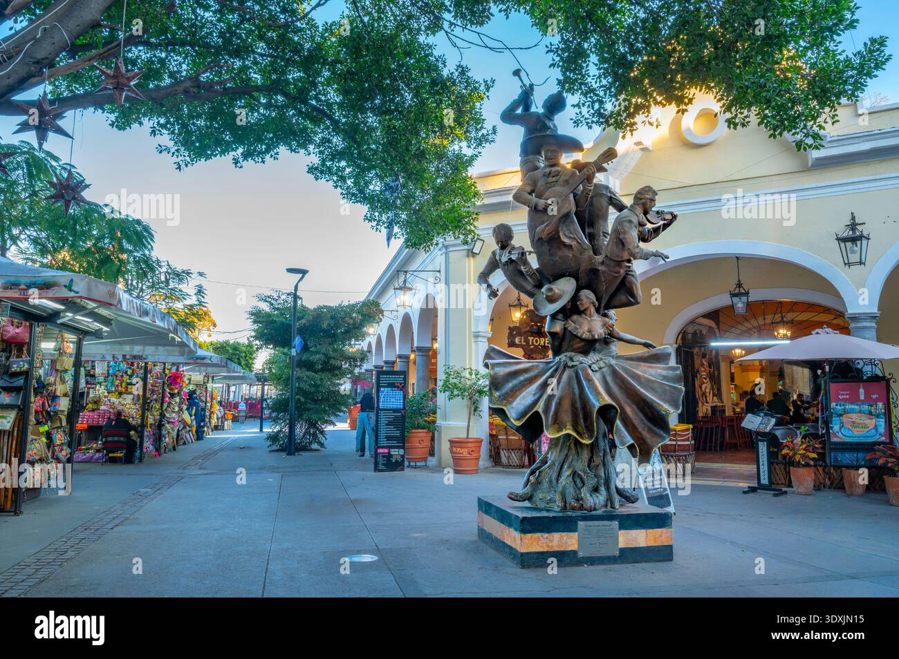 Belebte Fußgängerzone in Tlaquepaque Guadalajara Jalisco Mexiko mit Eingang El Parian und traditioneller Mariachi-Skulptur. Farbenfrohe Souvenirs Stockfoto