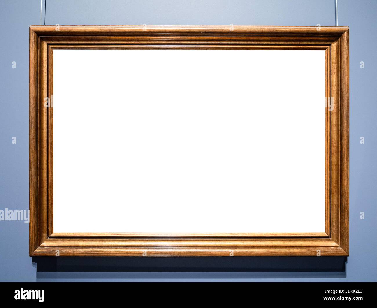 Horizontaler alter brauner Holzrahmen mit ausgeschnittener Leinwand, die an der blauen Wand hängt Stockfoto