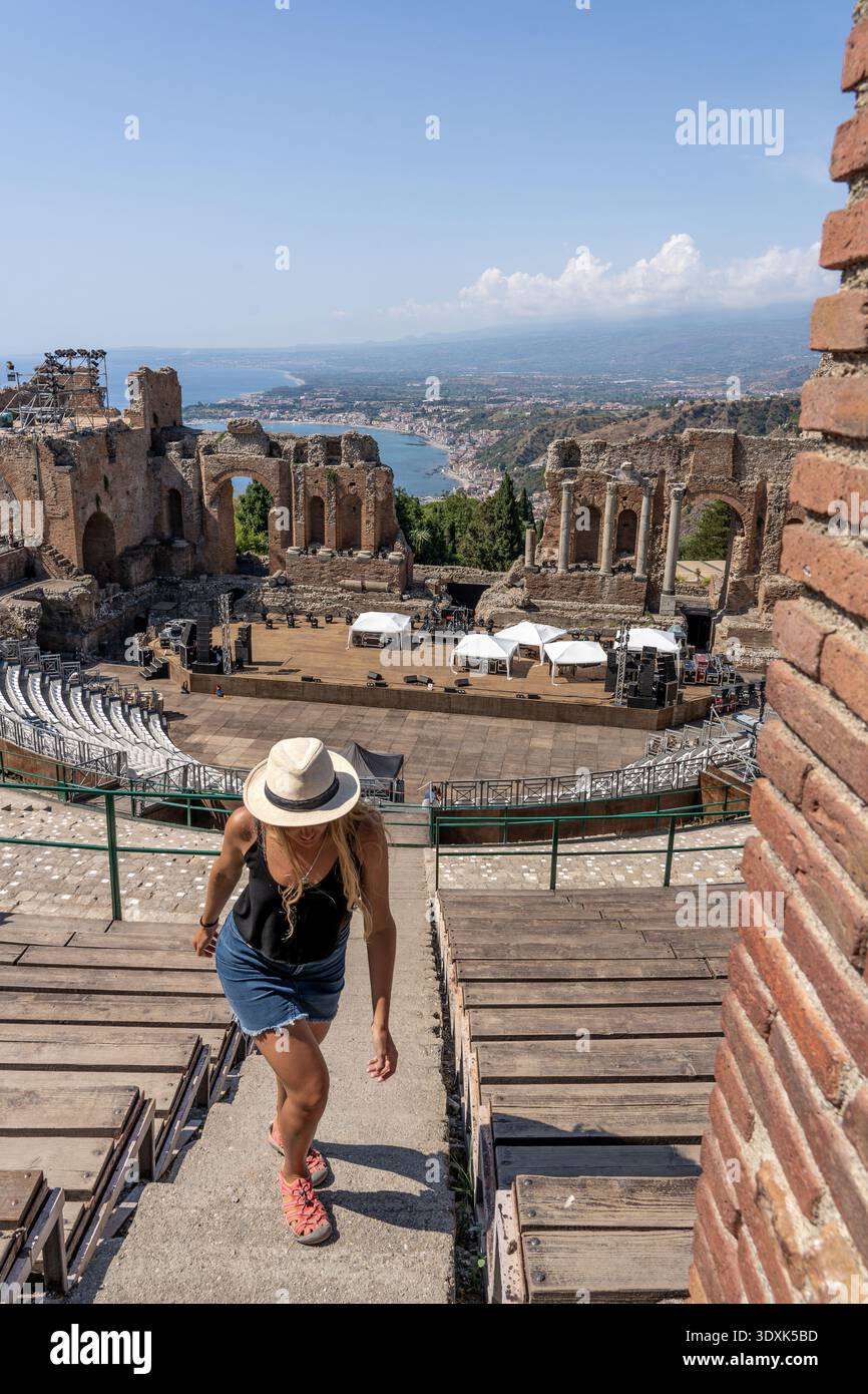 Frau klettert Treppen im antiken Theater Taormina mit Meerblick Stockfoto