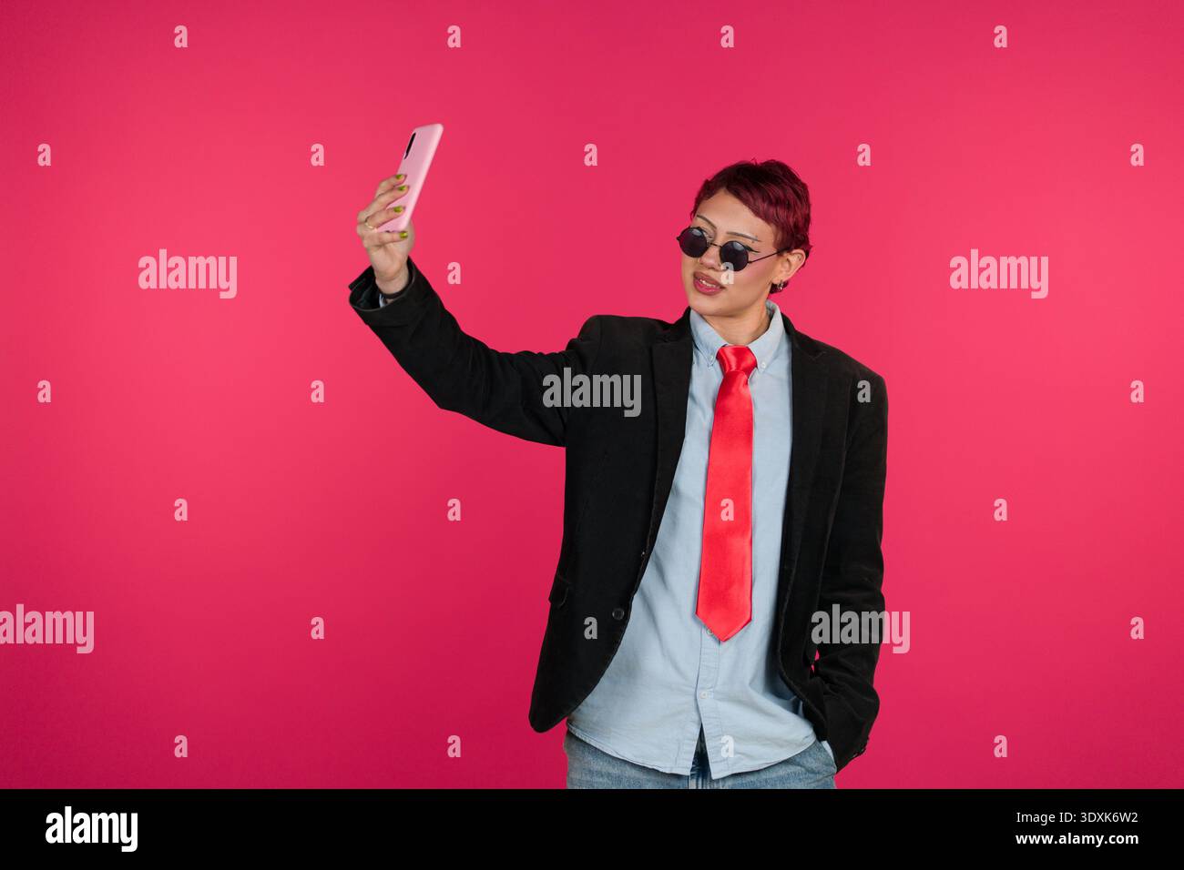 Junge Person, die ein Smartphone-Selfie auf rosa Hintergrund macht Stockfoto