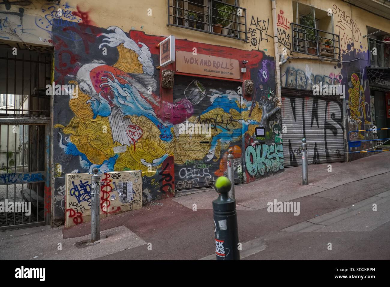 Wok and Roll's Restaurant japonais, Marseille, Frankreich. Die Fassade des japanischen Restaurants ist mit lebendigen, detaillierten Straßenkunst-Wandgemälden im Künstlerviertel bedeckt. Stockfoto