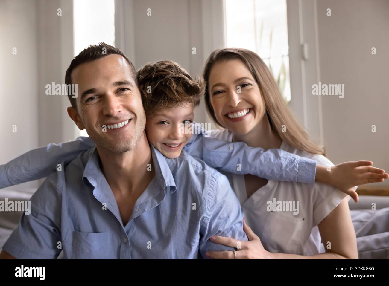 Porträt glücklicher Eltern, die posieren, mit Kind in die Kamera schauen Stockfoto