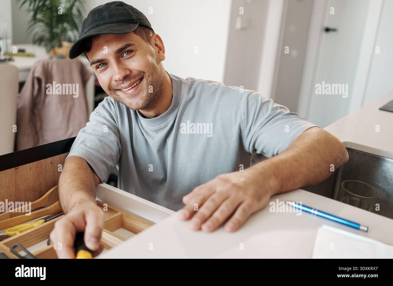 Eine Person Überprüft Die Position Des Schranks Sorgfältig. Man Konzentriert Sich Auf Präzise Messungen Bei Der Kücheneinstellung Stockfoto