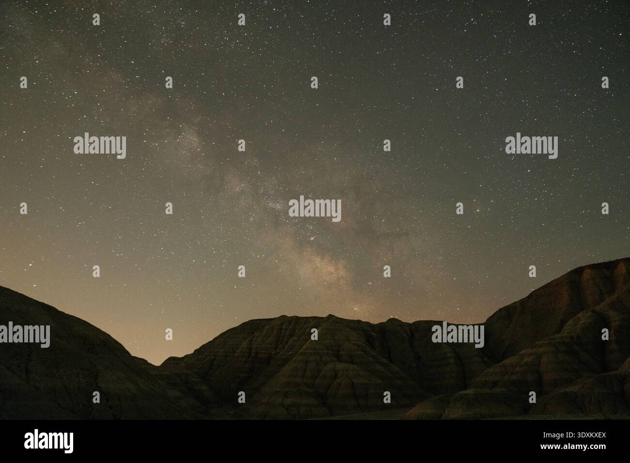 Dramatische Nachtszene mit der Milchstraße-Galaxie über dunklen Bergsilhouetten, aufgenommen mit Langzeitbelichtungsaufnahmen. Stockfoto