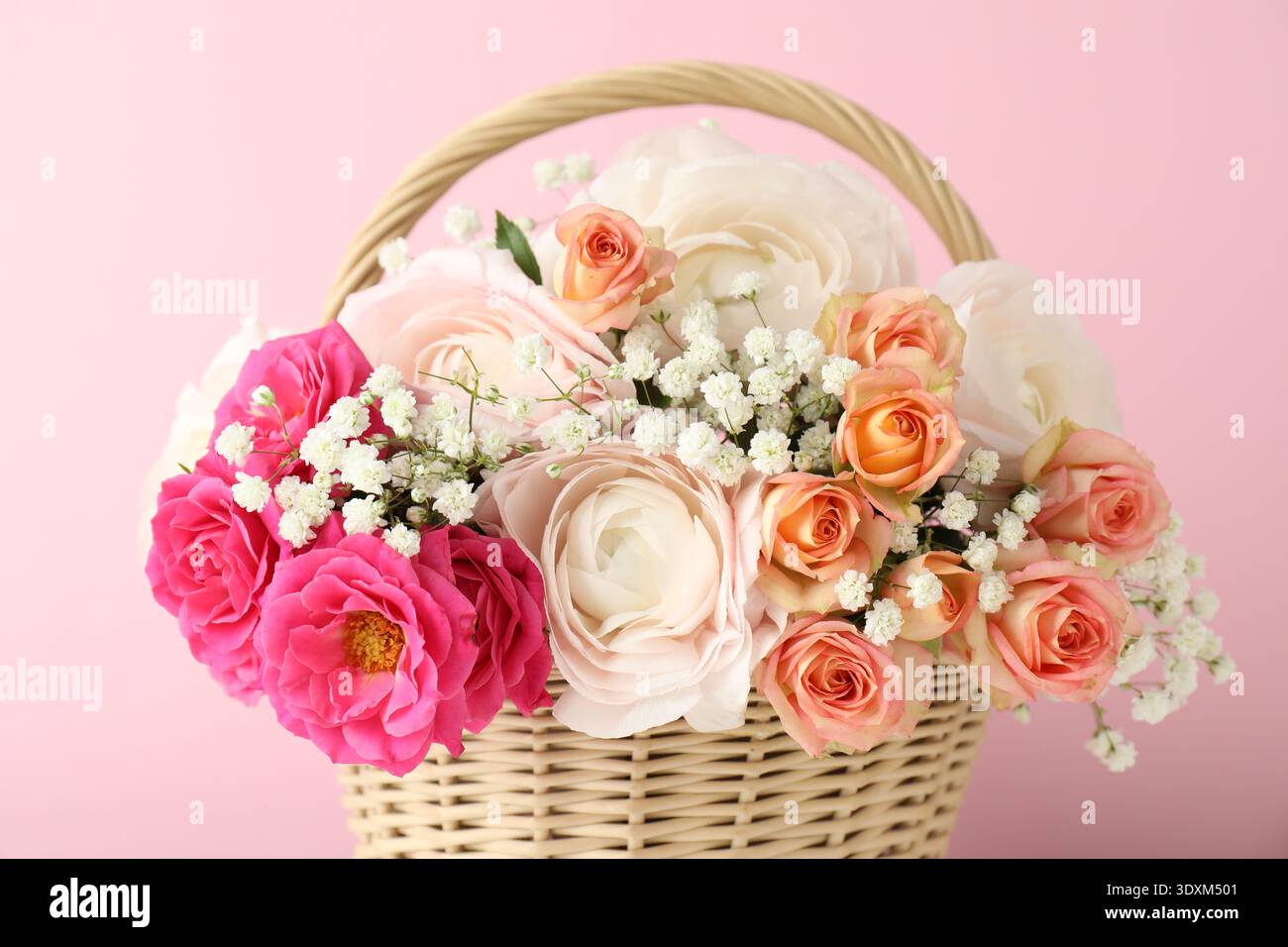 Schöne Blumen im Korb auf rosa Hintergrund, Nahaufnahme Stockfoto